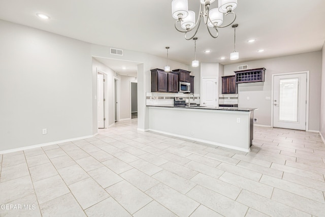 kitchen featuring decorative backsplash, appliances with stainless steel finishes, kitchen peninsula, dark brown cabinetry, and pendant lighting