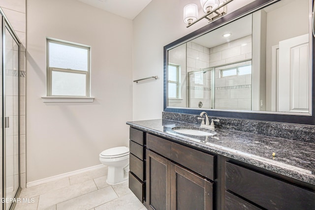 bathroom with tile patterned flooring, vanity, a wealth of natural light, and a shower with shower door