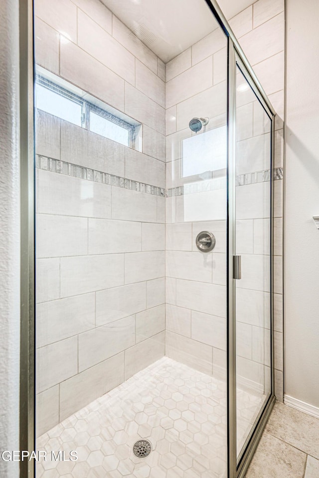 bathroom featuring a shower with shower door