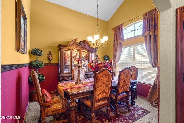 carpeted dining area with a chandelier and lofted ceiling