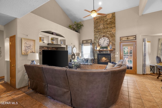 tiled living room featuring built in features, ceiling fan, high vaulted ceiling, and a fireplace