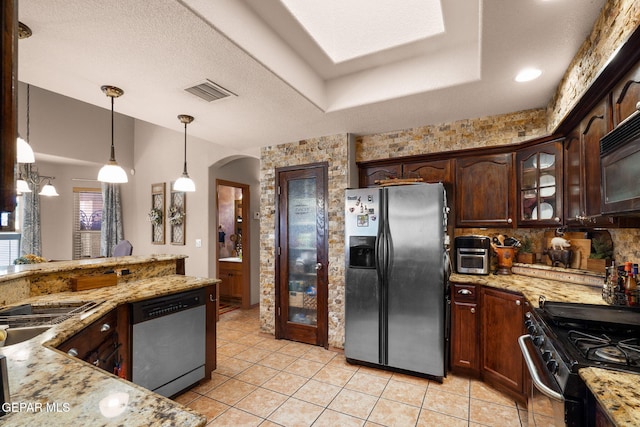 kitchen featuring dark brown cabinets, decorative light fixtures, light tile patterned floors, light stone counters, and stainless steel appliances