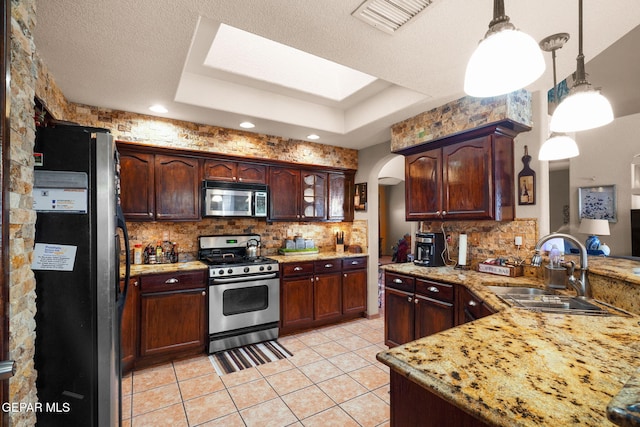 kitchen featuring appliances with stainless steel finishes, sink, hanging light fixtures, backsplash, and light tile patterned floors