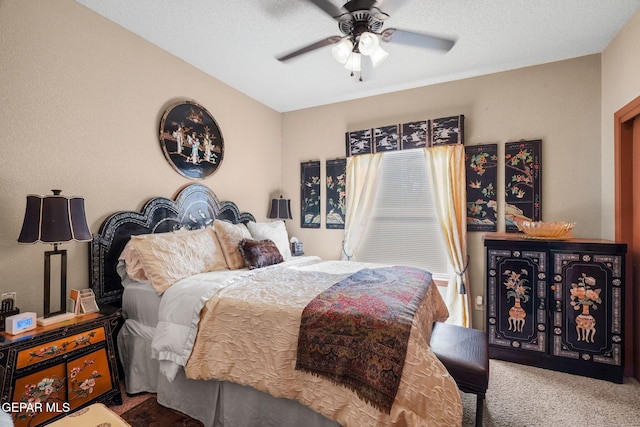 carpeted bedroom featuring ceiling fan and a textured ceiling