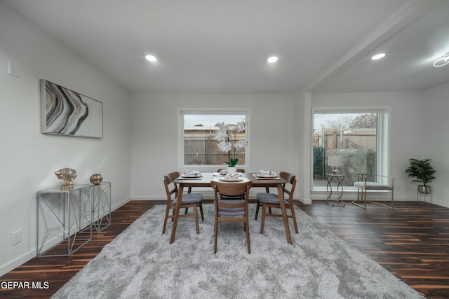 dining space featuring dark hardwood / wood-style flooring and beam ceiling