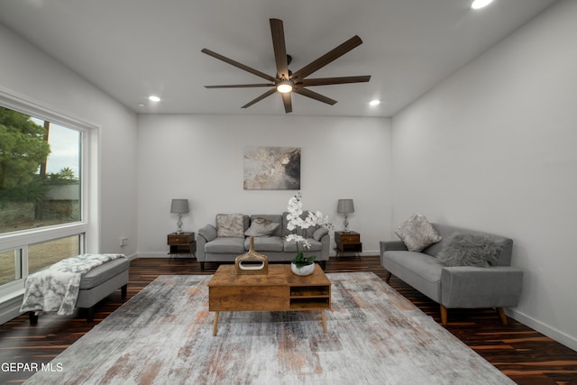 living room featuring dark wood-type flooring and ceiling fan