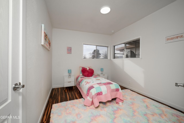 bedroom with dark hardwood / wood-style floors