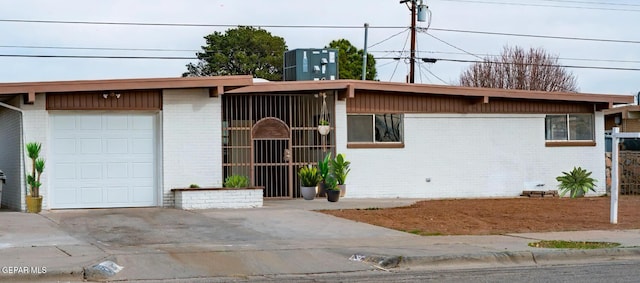 view of front of house with a garage and central AC