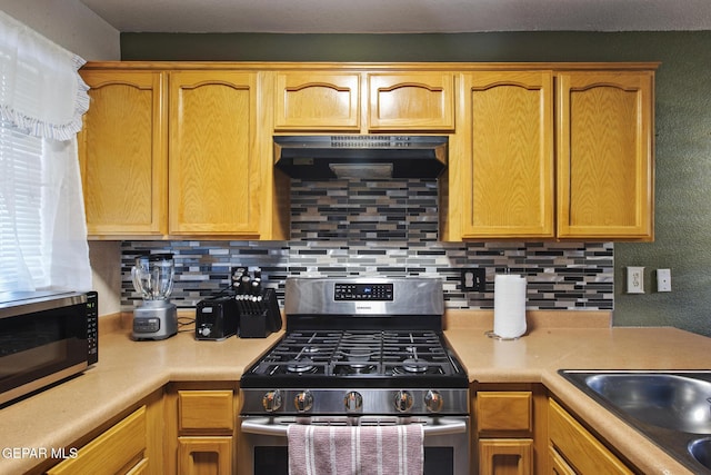 kitchen with decorative backsplash, stainless steel appliances, and sink