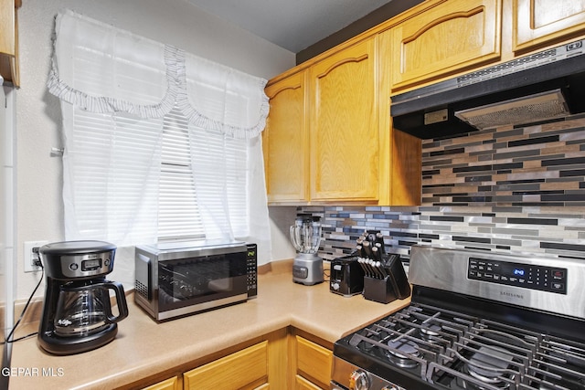 kitchen with stainless steel range with gas cooktop and tasteful backsplash