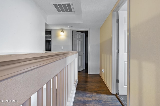 hall with dark hardwood / wood-style flooring and a textured ceiling