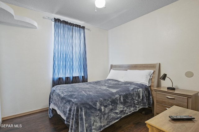 bedroom featuring a textured ceiling and dark hardwood / wood-style floors