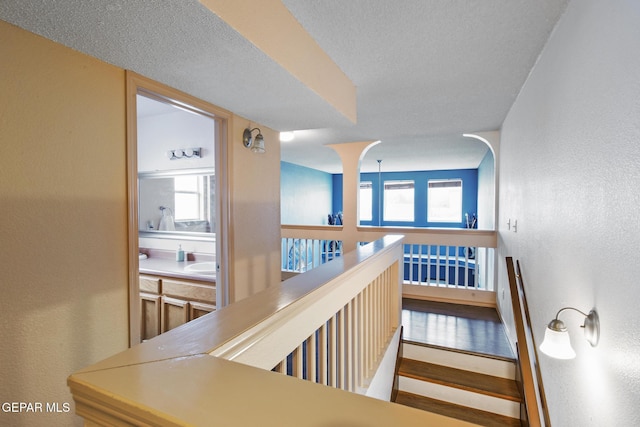 corridor featuring a healthy amount of sunlight and a textured ceiling