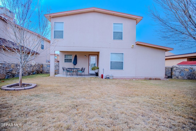 back of house with a lawn and a patio area