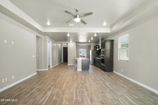 kitchen featuring a center island with sink, ceiling fan, sink, and stainless steel appliances