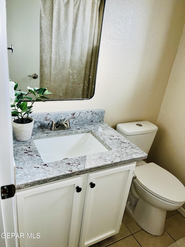 bathroom featuring toilet, vanity, and tile patterned floors