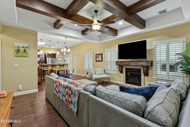 living room with coffered ceiling and ceiling fan with notable chandelier