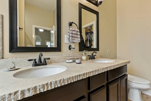 bathroom featuring vanity, ceiling fan, and toilet