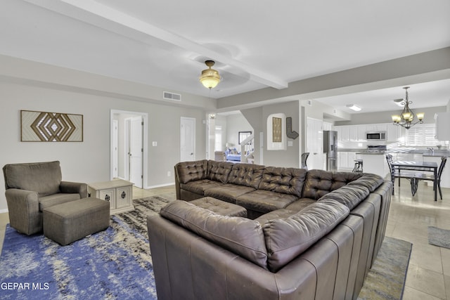 living room with beamed ceiling, ceiling fan with notable chandelier, and light tile patterned floors