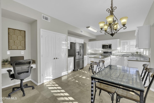 dining space with sink and a chandelier