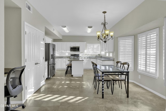 dining room with light tile patterned floors and an inviting chandelier