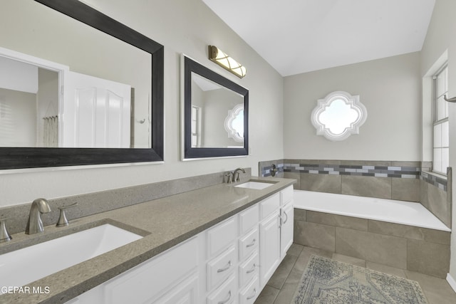 bathroom with vanity and tiled bath