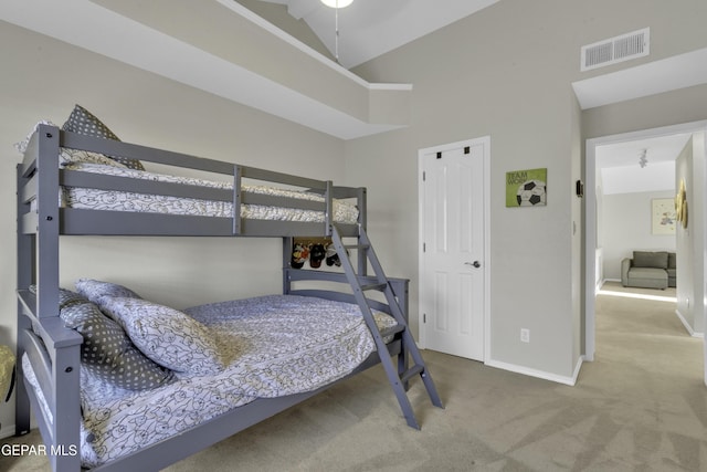 carpeted bedroom with high vaulted ceiling