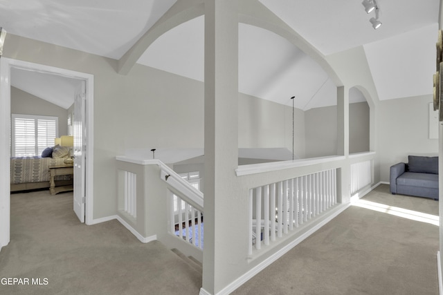 corridor with light colored carpet and lofted ceiling