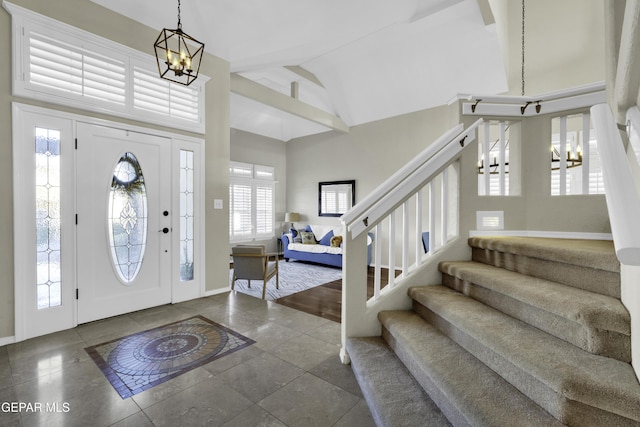 tiled entrance foyer with high vaulted ceiling and a notable chandelier