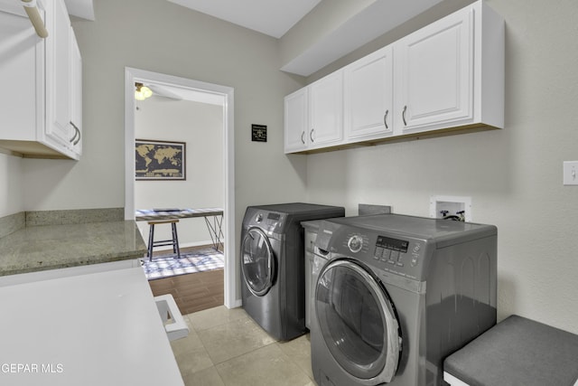 clothes washing area with cabinets, light tile patterned floors, washing machine and dryer, and ceiling fan