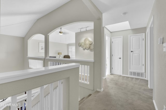 corridor featuring light carpet and lofted ceiling