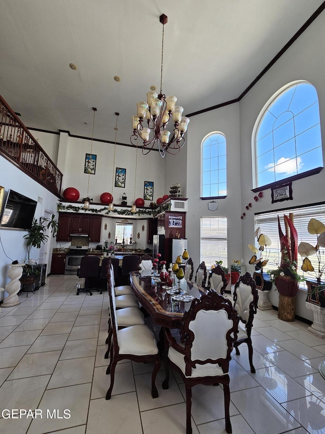 dining area featuring light tile patterned floors, a notable chandelier, and a high ceiling