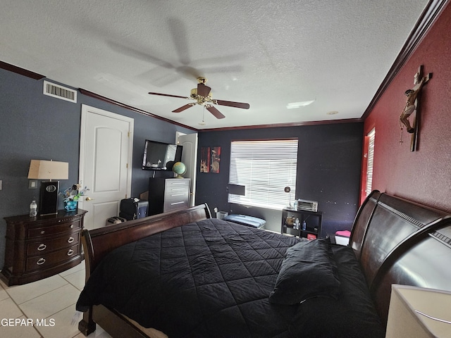 tiled bedroom featuring ceiling fan, ornamental molding, and a textured ceiling