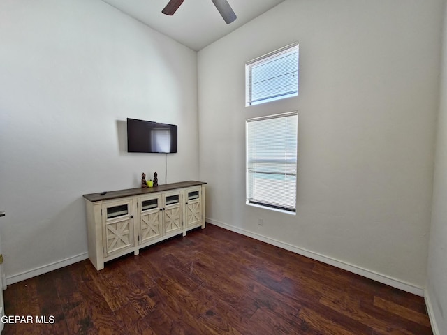 living room with ceiling fan and dark wood-type flooring