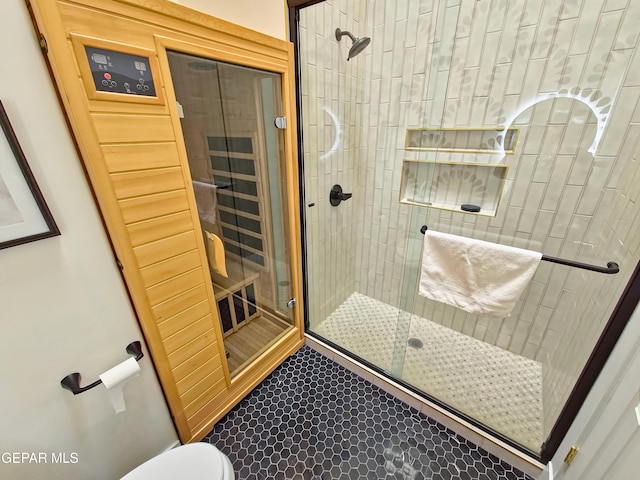 bathroom with toilet and a shower with shower door