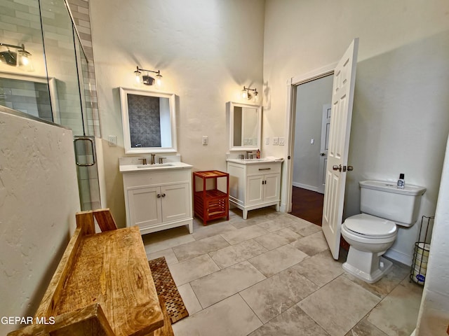 bathroom with vanity, a shower with shower door, and toilet