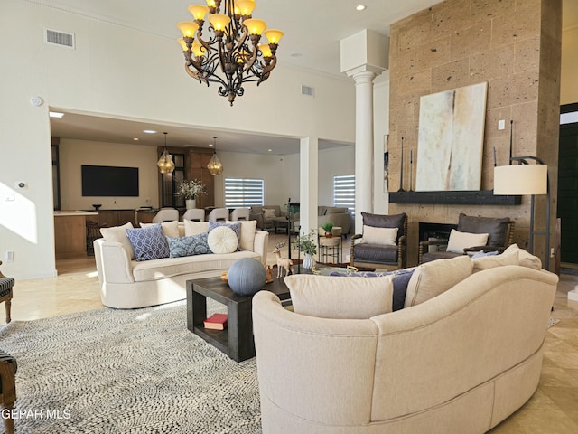 living room with ornate columns, a towering ceiling, ornamental molding, and an inviting chandelier