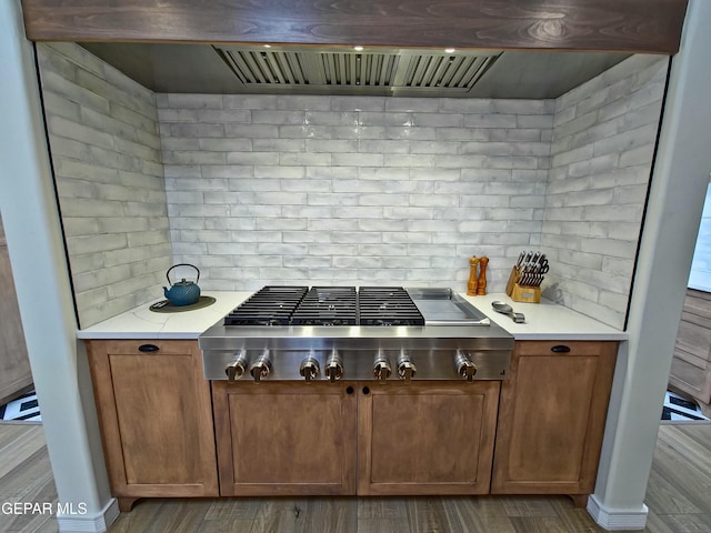 kitchen with ventilation hood, decorative backsplash, light hardwood / wood-style floors, and stainless steel gas cooktop