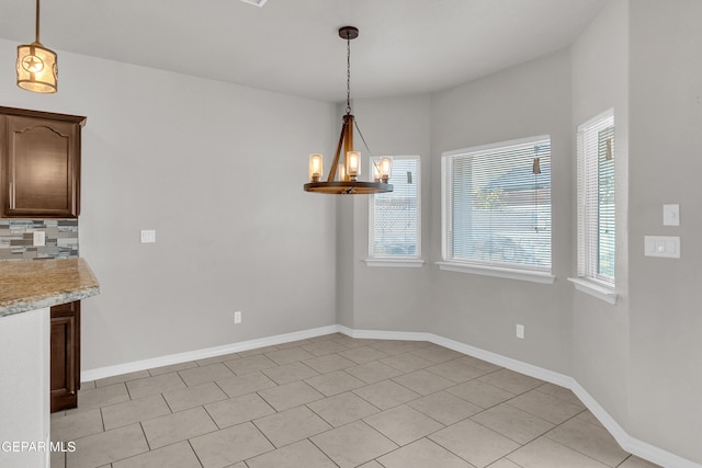 unfurnished dining area with light tile patterned flooring and a notable chandelier