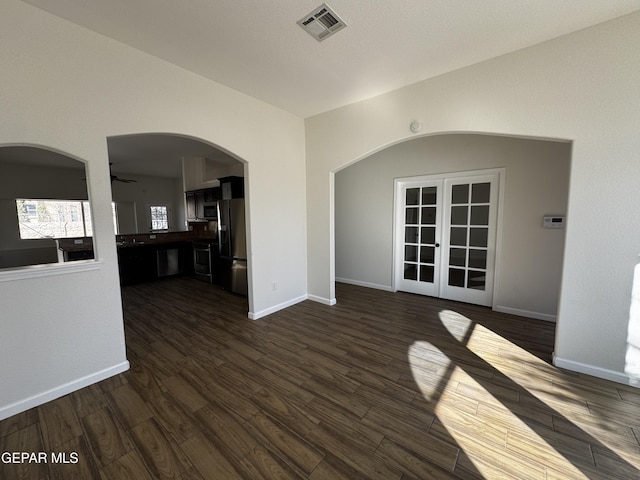 spare room featuring ceiling fan, french doors, and dark hardwood / wood-style floors