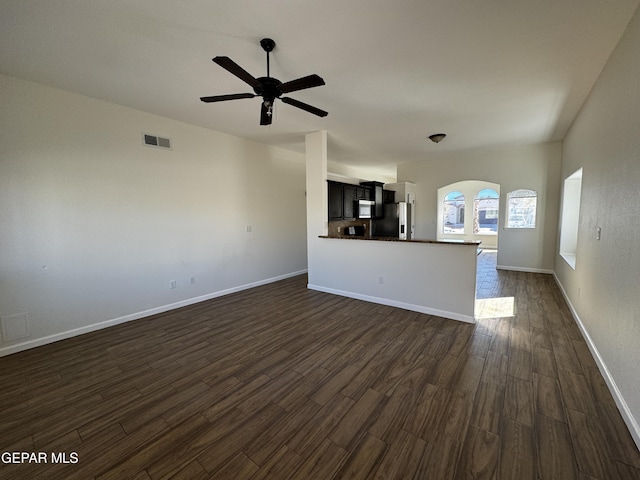 unfurnished living room featuring ceiling fan and dark hardwood / wood-style floors