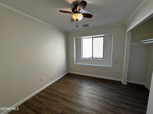 unfurnished bedroom with ceiling fan, dark hardwood / wood-style flooring, a closet, and crown molding