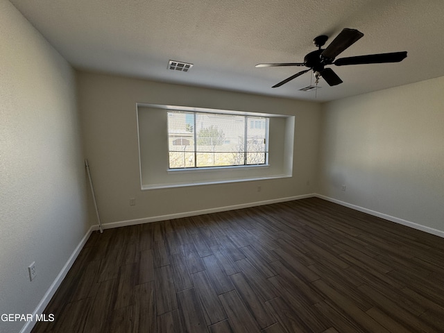 empty room featuring dark hardwood / wood-style flooring, a textured ceiling, and ceiling fan