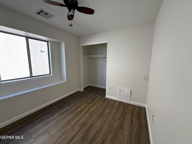 unfurnished bedroom with a closet, ceiling fan, and dark wood-type flooring