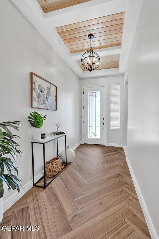 foyer entrance with an inviting chandelier and parquet floors