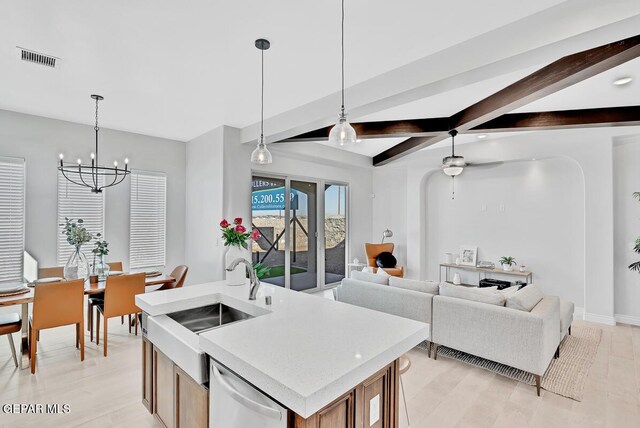 kitchen featuring dishwasher, sink, beamed ceiling, a center island with sink, and ceiling fan with notable chandelier