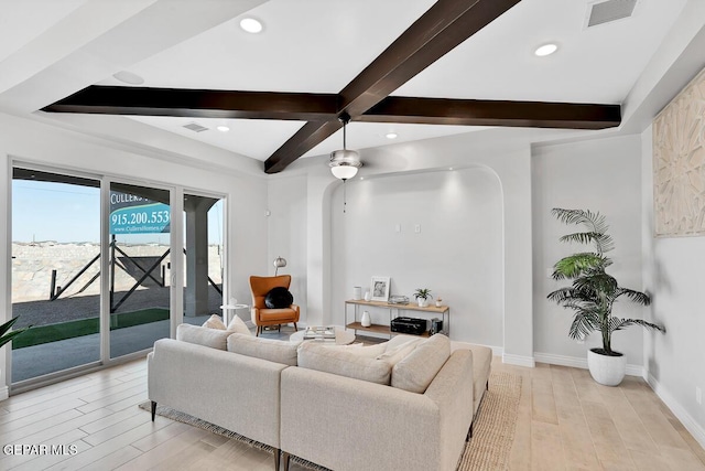 living room featuring beamed ceiling and light hardwood / wood-style flooring