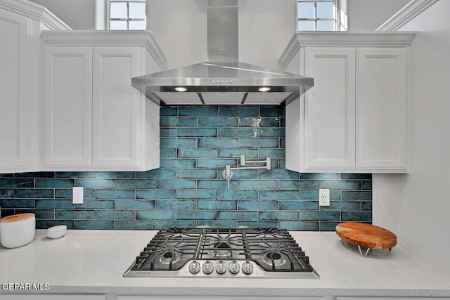 kitchen with backsplash, white cabinetry, wall chimney exhaust hood, and stainless steel gas cooktop