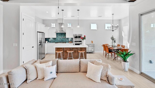 kitchen with a kitchen island with sink, hanging light fixtures, tasteful backsplash, a breakfast bar area, and stainless steel appliances