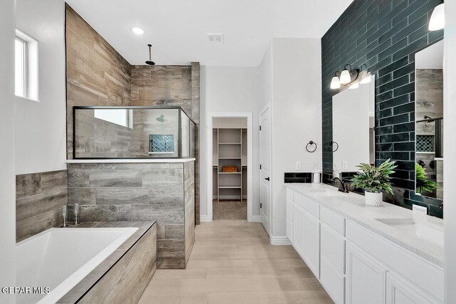 bathroom with vanity, plus walk in shower, and tile walls